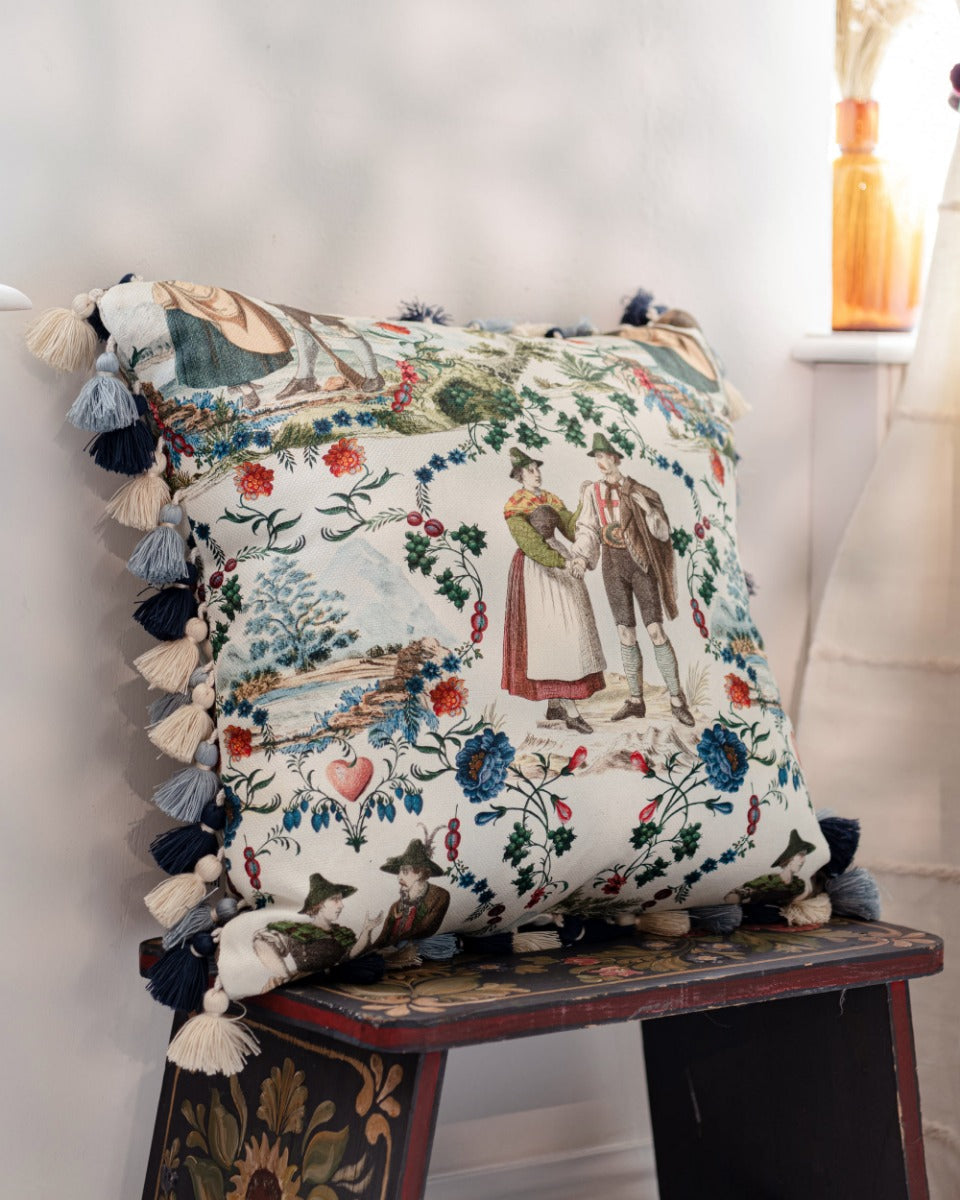 LANDHAUSMODE Cushion (LC40197) by Mind The Gap | LC40197 | TYROL APRES-SKI | 50 x 50 cm | Blue, White, Green, Red | Fringes all around | Duck feather | 56% Cotton, 44% Linen | Fabric Carolina | https://www.fabriccarolina.com/